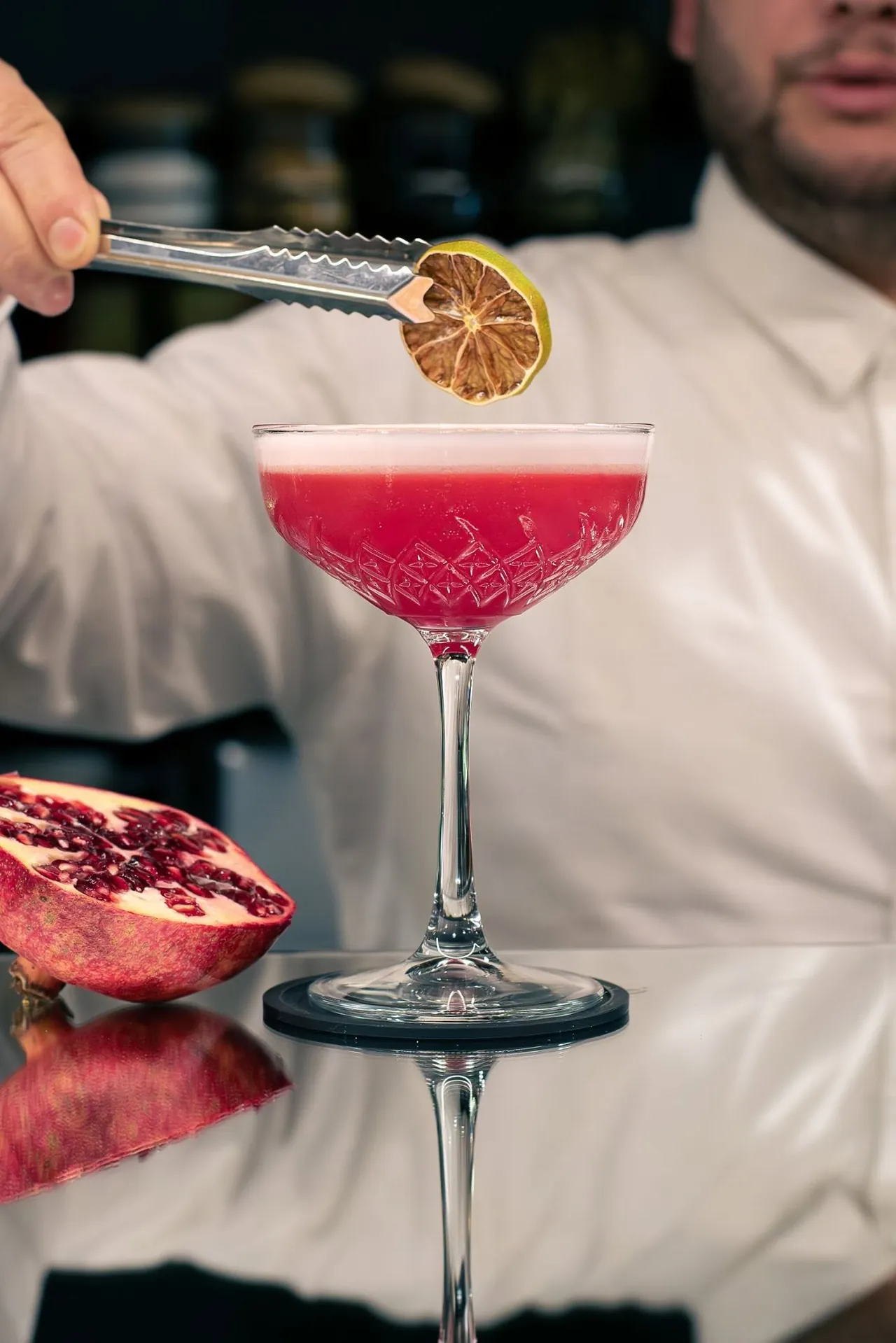 Barmanul pune garnitura pe un cocktail