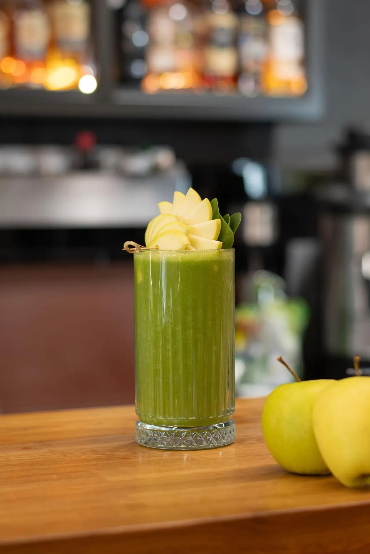 Cocktail verde pe bar, cu mere
